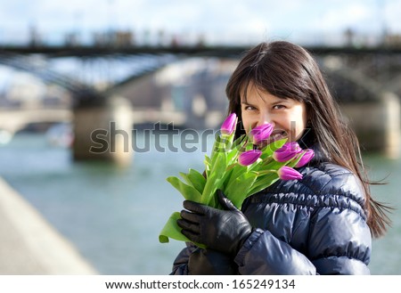 Happy beautiful girl with tulips enjoying spring day in Paris
