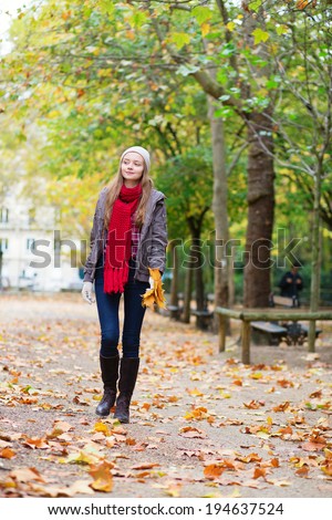 Beautiful young girl walking in a park on a fall day