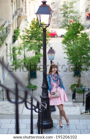 Beautiful girl in pink dress on Montmartre in Paris