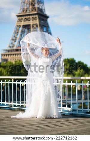 Beautiful elegant bride with long veil near the Eiffel tower in Paris