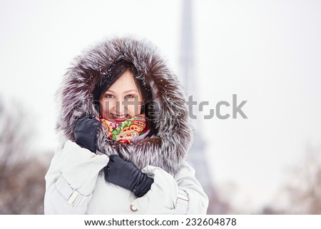Beautiful young woman enjoying rare snowy winter day in Paris