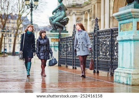 Three young cheerful girls walking together in Paris