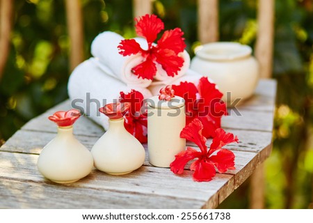 Spa setting with towels and beautiful red hibiscus flowers