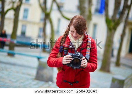 Happy young tourist in Paris, walking in the street with photo camera