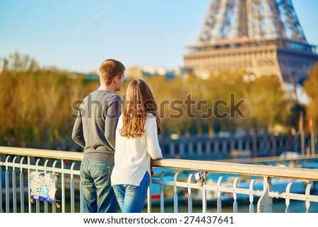 Young romantic couple in Paris having fun near the Eiffel tower