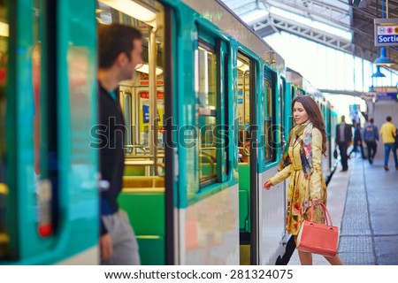 Young beautiful Parisian woman on a subway station, running to catch her train on the platform