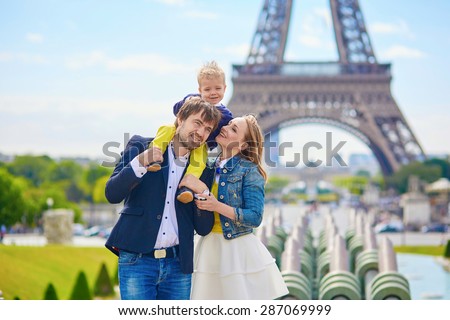 Happy family of three having fun together in Paris near the Eiffel tower