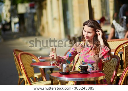 Beautiful young woman in a Parisian street cafe, enjoying sunny week-end