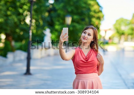 Beautiful young tourist walking in the street in Vienna, Austria and taking selfie