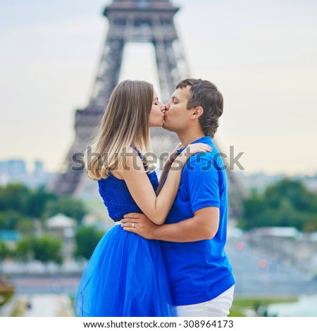 Romantic dating couple on Trocadero viewpoint in Paris, hugging and kissing, Eiffel tower is in the background