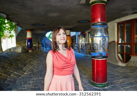 Beautiful young woman walking in Vienna, Austria near Hundertwasser house