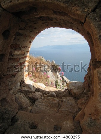 Flowers through a lookout hole. Nafplion, Greece. Part of the defense of an ancient castle on the hill top