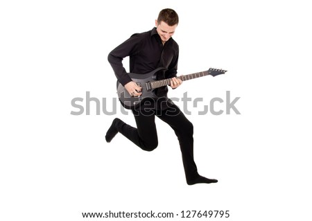 a young guy in black clothes plays the guitar, jumped isolated on white background