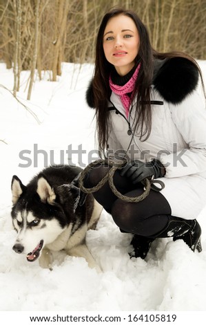 Girl on the nature of the dog in the winter