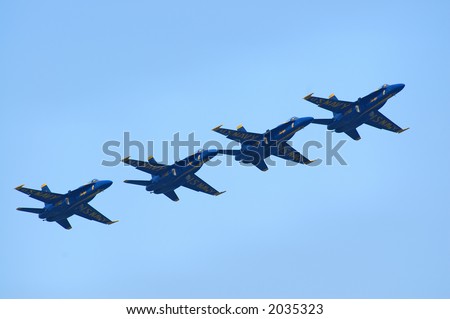 Blue Angels Navy Flight Demonstration team flying in tight formation at a diagonal across the image.
