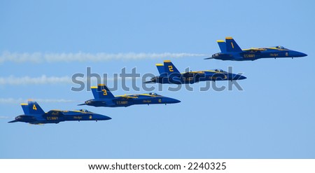 Four Blue Angels Navy Flight Demonstration Team planes flying horizontally in a tight formation during Fleet Week 2006 air show in San Francisco - pilots in yellow helmets clearly visible.