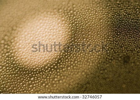 Closeup abstract of many condensated drops of water with a focus of light circle.