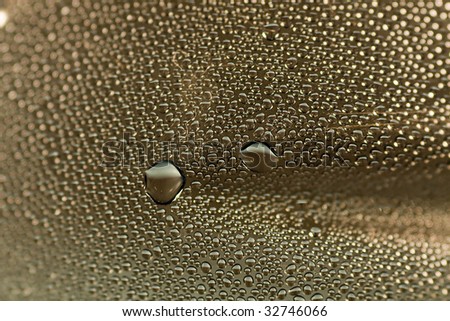 Closeup abstract of many condensated drops of water on a transparent surface.