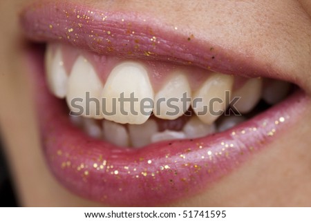 Close up view of some pink lips smiling.