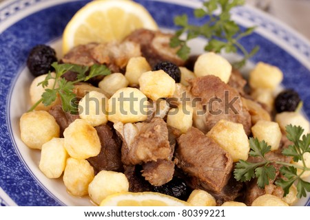 Close up view of a Portuguese meal of cooked meat with potatoes.