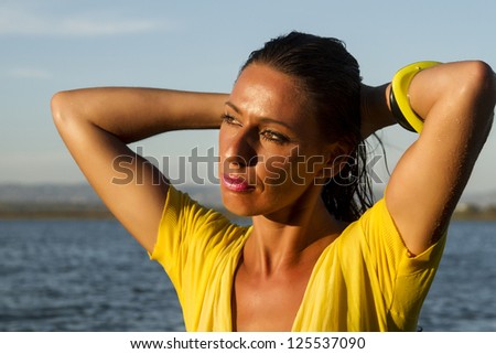 View of a beautiful woman in bikini in the beach, bathed by the sunny rays of Summer.
