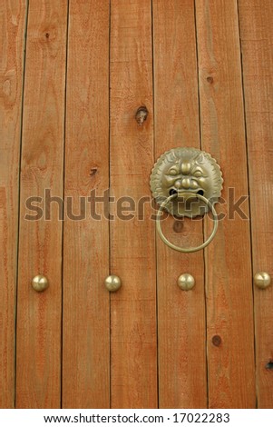 Asian style wooden door with ornate metal door handle. Suitable for background use