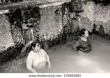 BALI, INDONESIA - JULY 10: Two unidentified women are bathing in the Banjar springs. Volcanous sources spew 38Ã?Â°C hot sulphorous water, believed to cure skin diseases.. July 10 2012, Bali Indonesia.