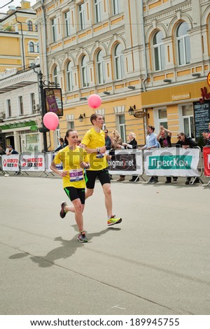 KYIV, UKRAINE - APRIL 28: Young couple runs with red balloons during 5-th Wizz Air Kyiv City Marathon, a competition run of 42 km held in the old city center on April 28, 2013 in Kyiv, Ukraine.