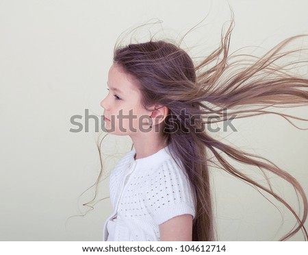 Portrait of a young girl with developing hairs in the wind.