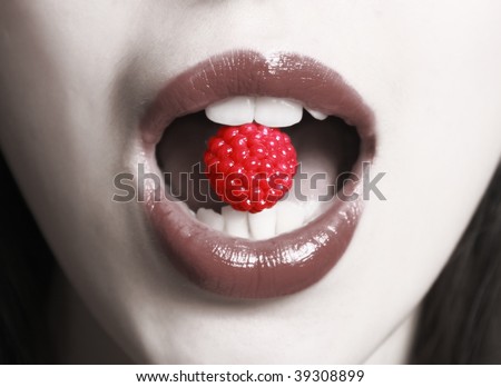 The open mouth with a berry in a teeth.