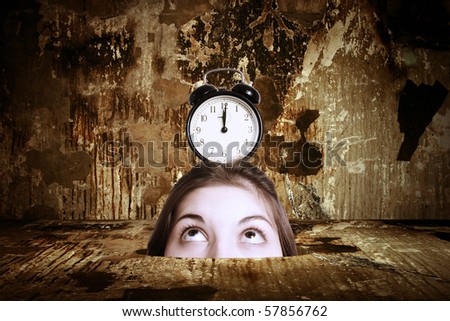 A head of the woman with an alarm clock in the thrown interior. Surrealistic composition.