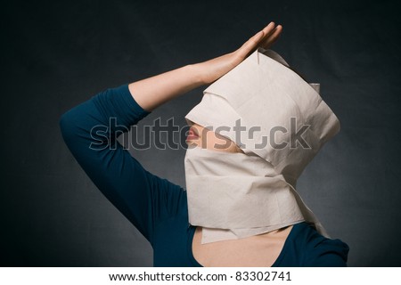 Young woman\'s head wrapped in paper. Symbol of loneliness and alienation.