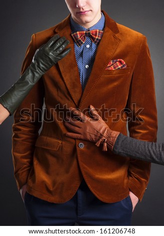 Stylish man in a red suit and women\'s hands in leather gloves.