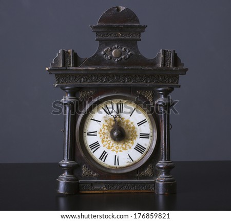 Vintage wooden clock on a dark background.