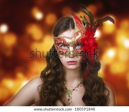 Woman in masquerade mask on a festive background.