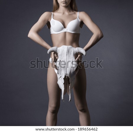 Perfect female body with cow skull in his hands.