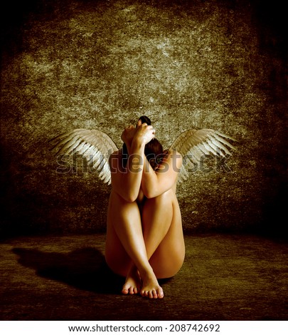 Naked girl with wings on his back sits burying its head. Fallen Angel.