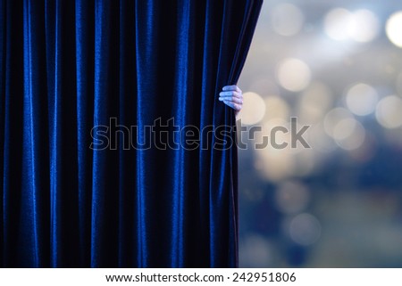 Man\'s hand opens the curtain.
