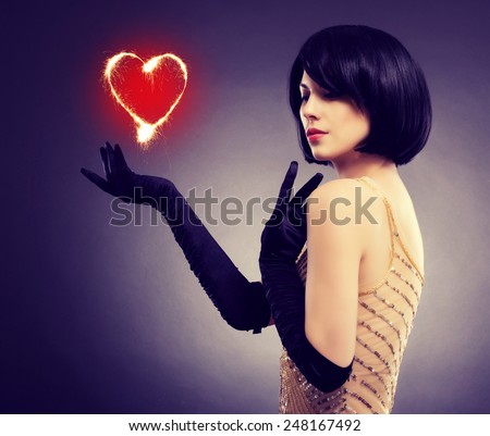 Beautiful stylish girl with a flaming heart in his hand. The concept of Valentine\'s Day.