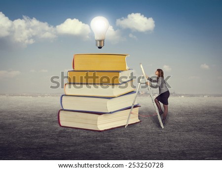 Businesswoman climbing the stairs to the foot of books for new ideas.