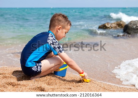 Boy play sand on the beach