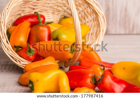 Mini bell peppers spilling out of wicker basket