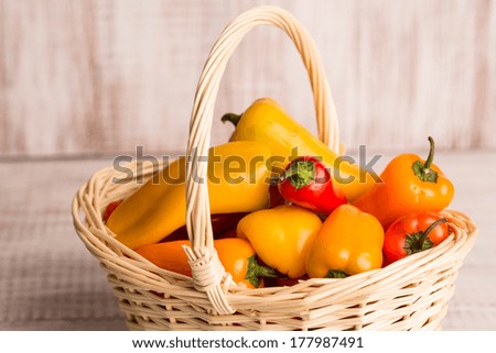 Mini bell peppers in wicker picnic basket close up