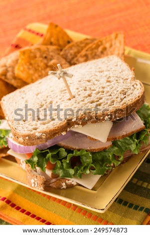 Healthy lunch turkey ham swiss cheese sandwich on wheat bread with chips