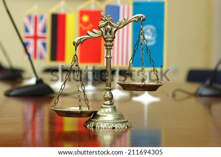 Decorative Scales of Justice with blurred National flag of different countries, concept of International Law and Order, focus on the scales
