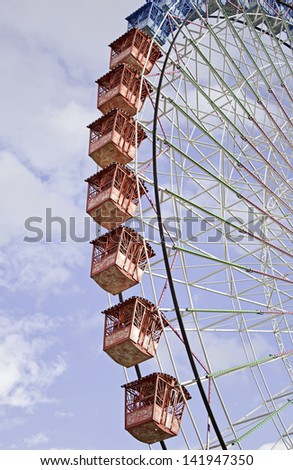 Ferris wheel in amusement park colors with metal booths, fun and party