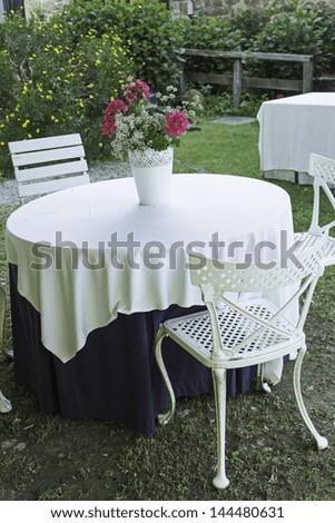 Restaurant table and chairs garden with flowers, and catering business