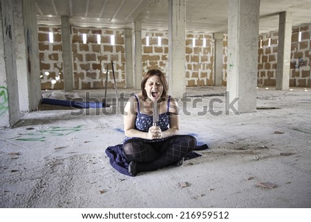 Woman with knife in abandoned house, fear and halloween