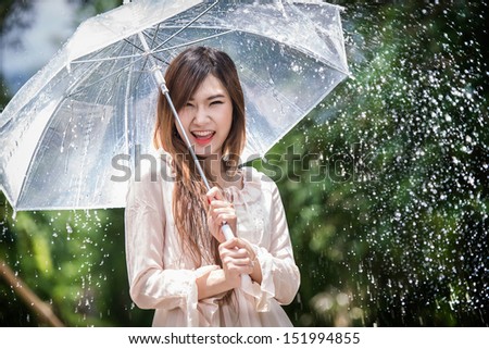 Happy Chinese girl is getting wet and rain