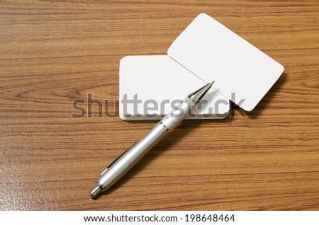 stack of business card with pen on wood background